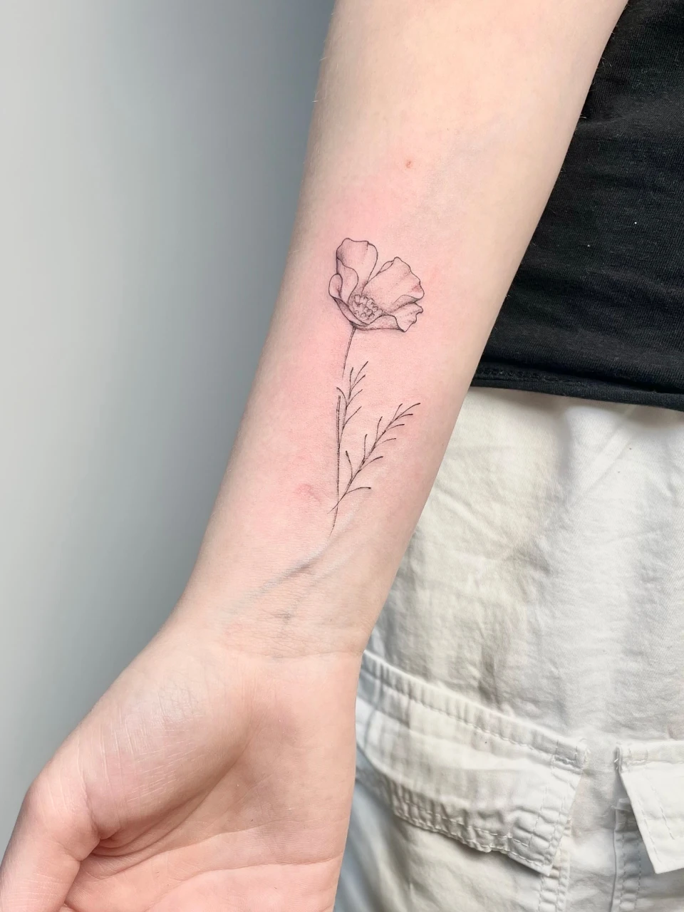 flower fine line tattoo on forearm