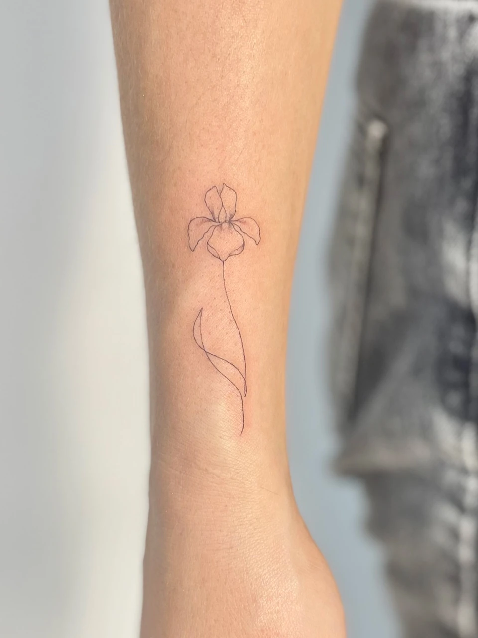 flower fine line tattoo on forearm