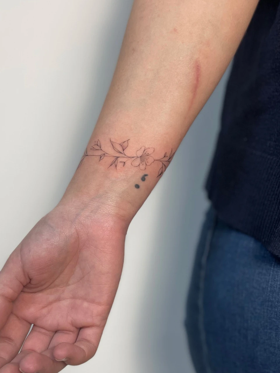 floral bracelet fine line tattoo on forearm