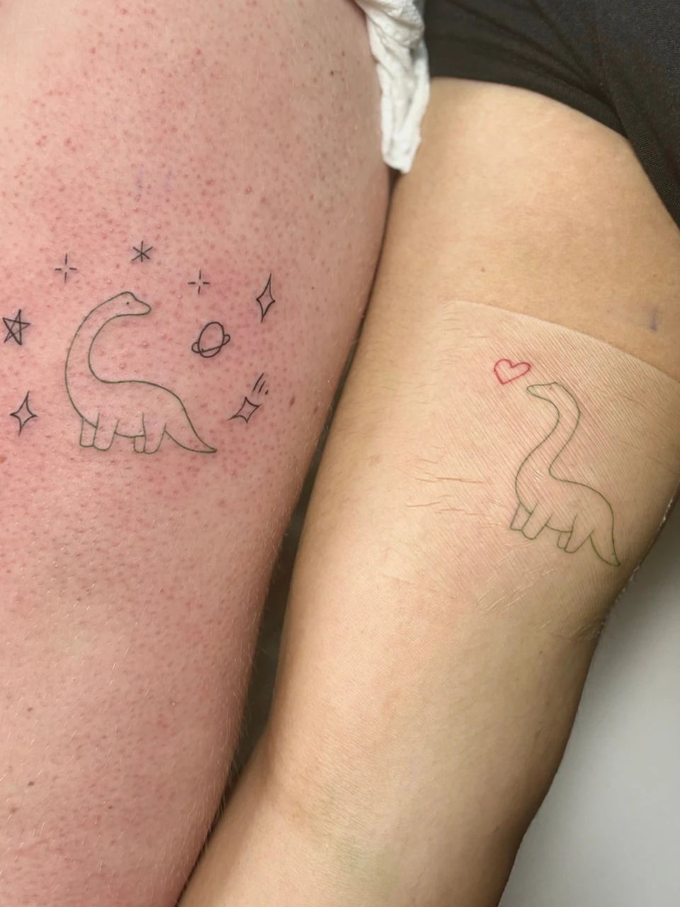 dinosaur fine line tattoo on forearm